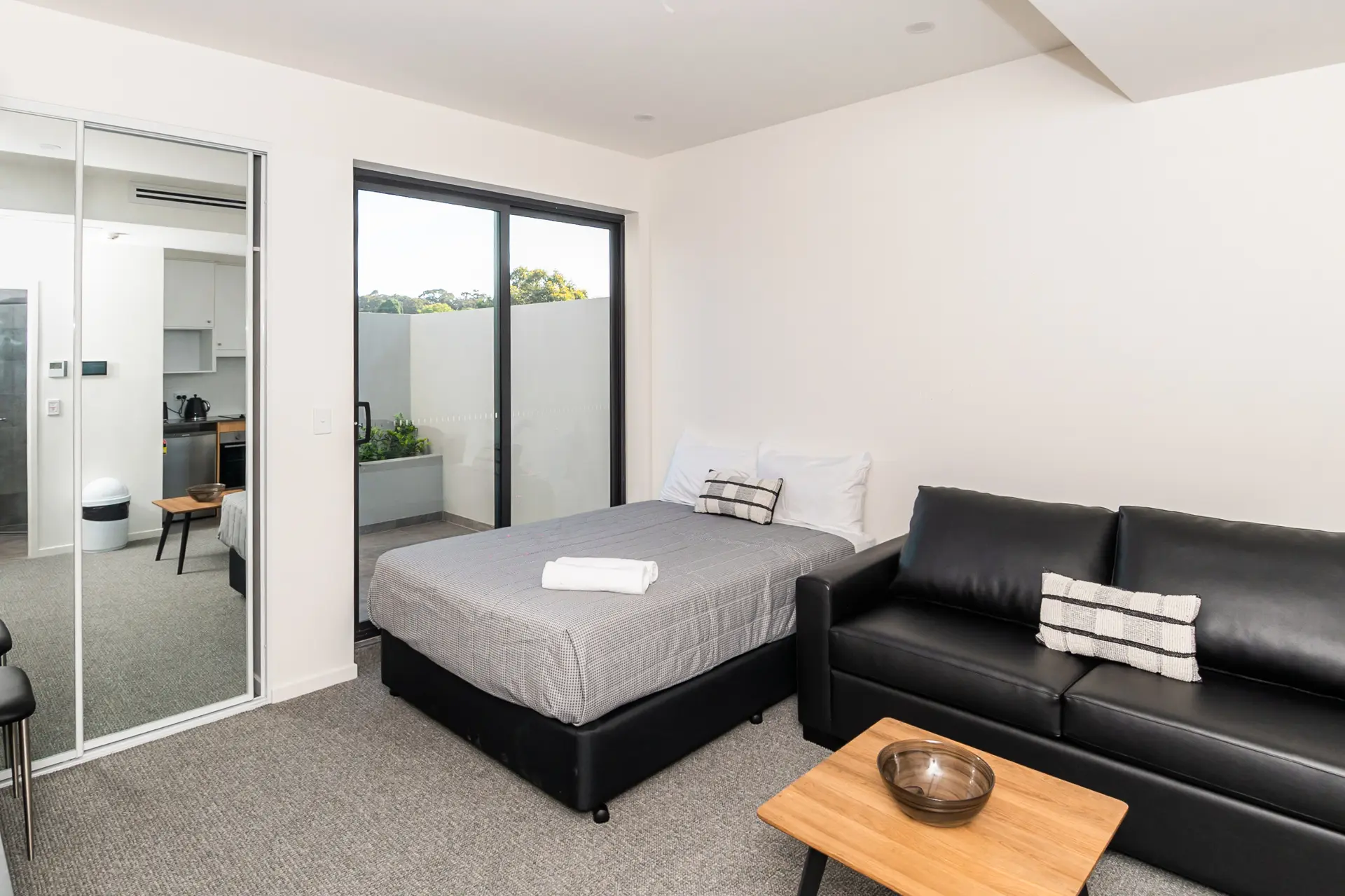 Wide view of a Jesmond Lodge studio apartment showing the bed, sofa and dining area together